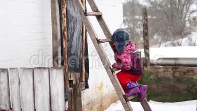 这个孩子在村里冬天爬上楼梯。